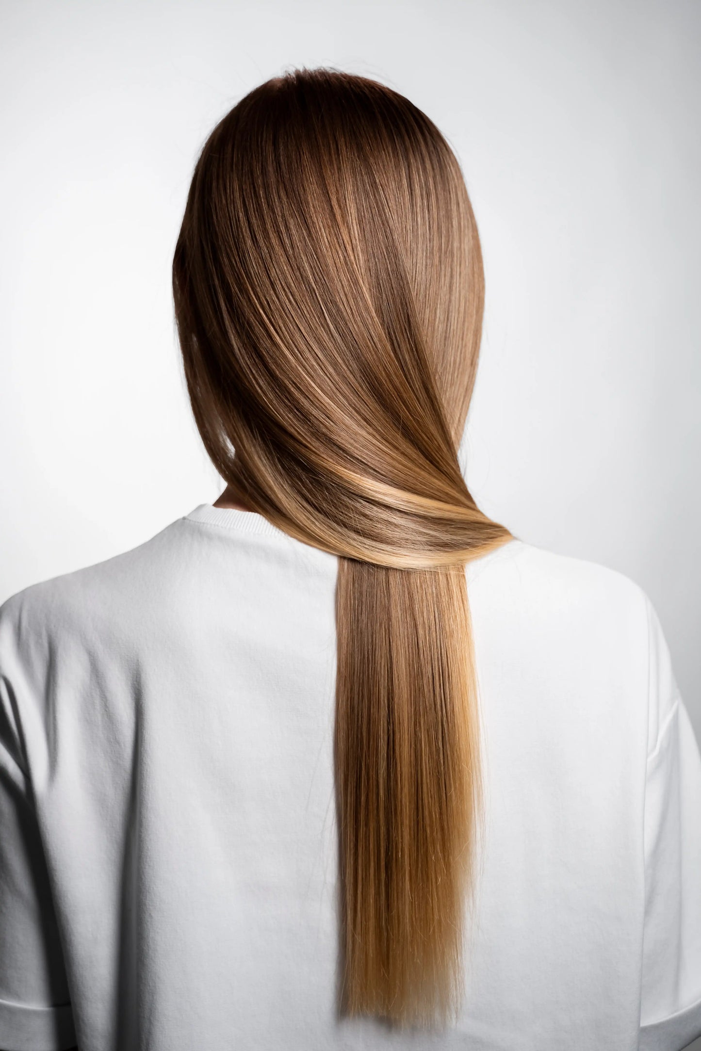 Person with long, straight hair against a white background.