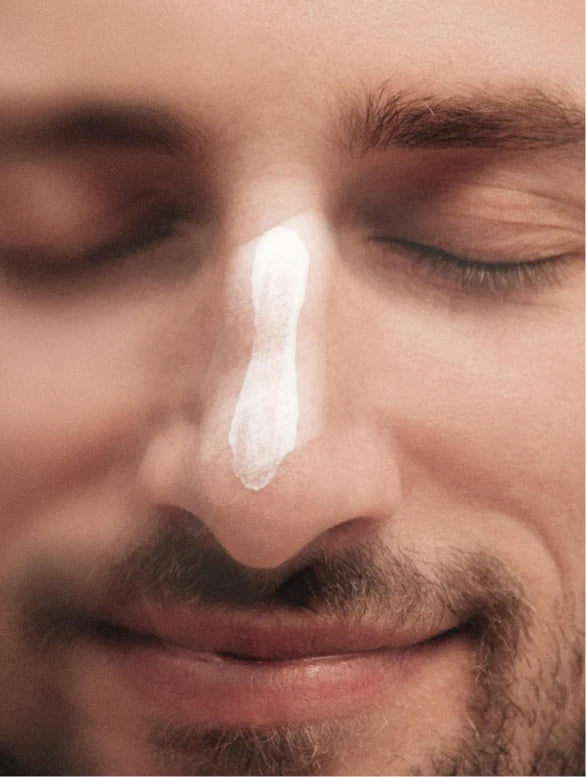 Moisturising cream applied on a man nose.