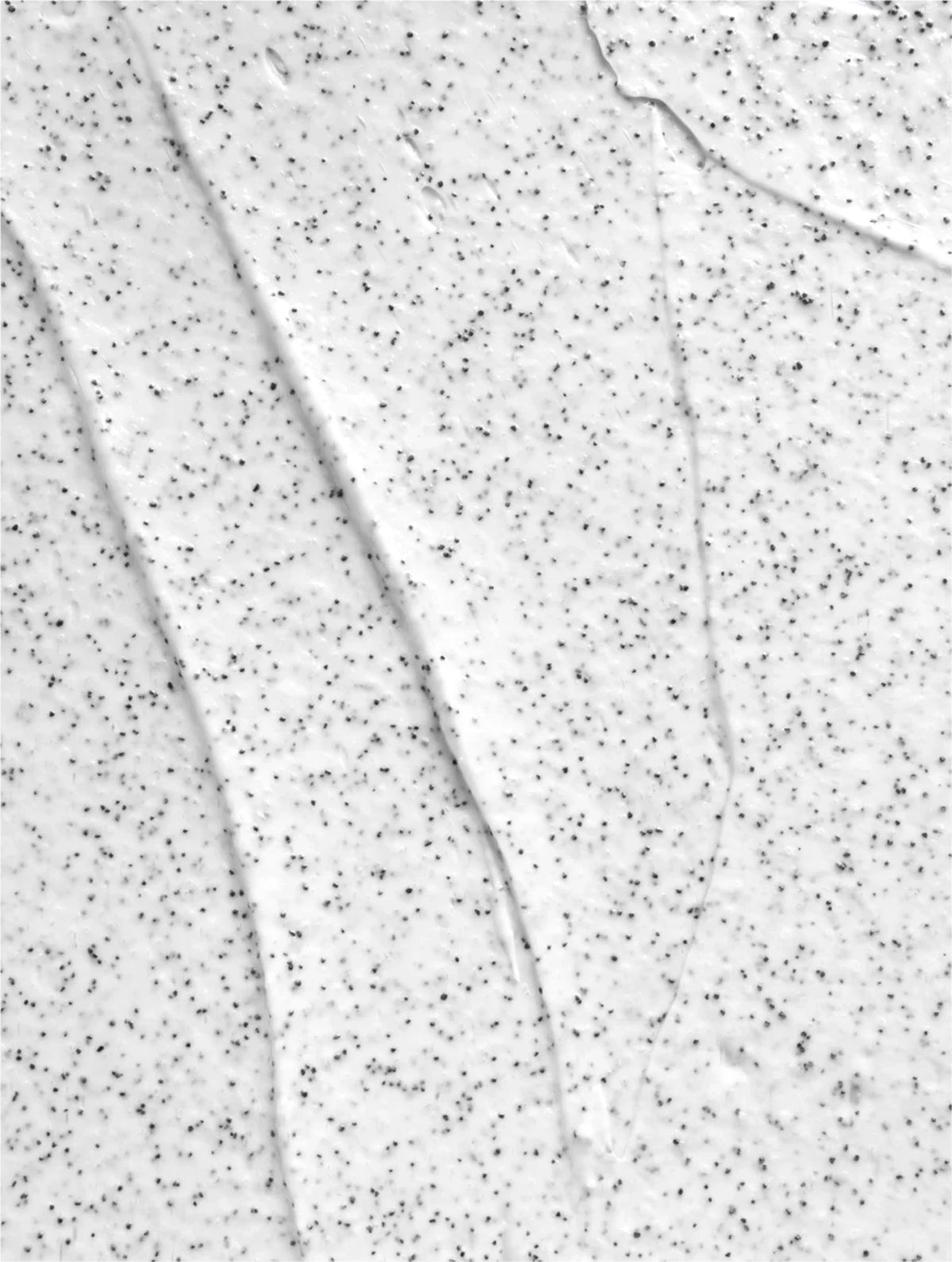 Close-up of a white scrub with black specks of volcano sand.